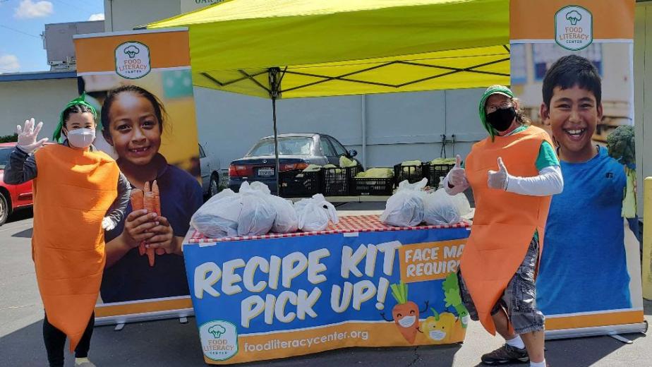 Employees in carrot costumes distributing recipe kits
