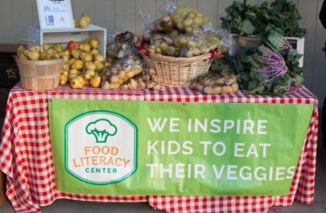 Table with produce and Food Literacy Center banner