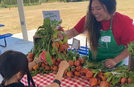 Volunteer giving beets to elementary students. 