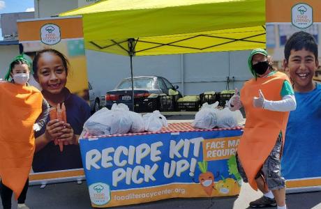 Employees in carrot costumes distributing recipe kits